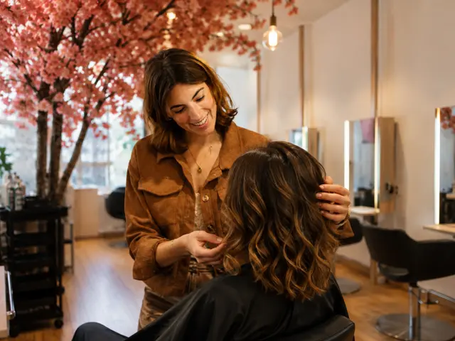 Coiffeuse visagiste analysant la morphologie du visage d'une cliente au salon Mylaa Evans Clermont-Ferrand