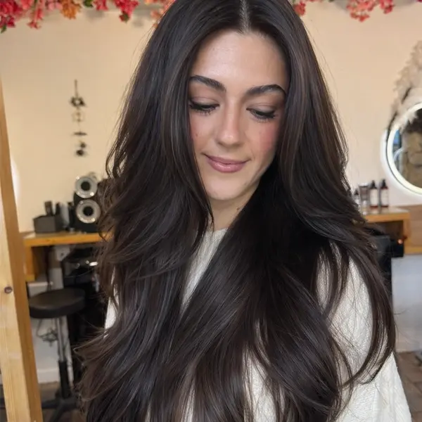Coupe visagiste sur cheveux longs bruns, longueurs travaillées en dégradé souple