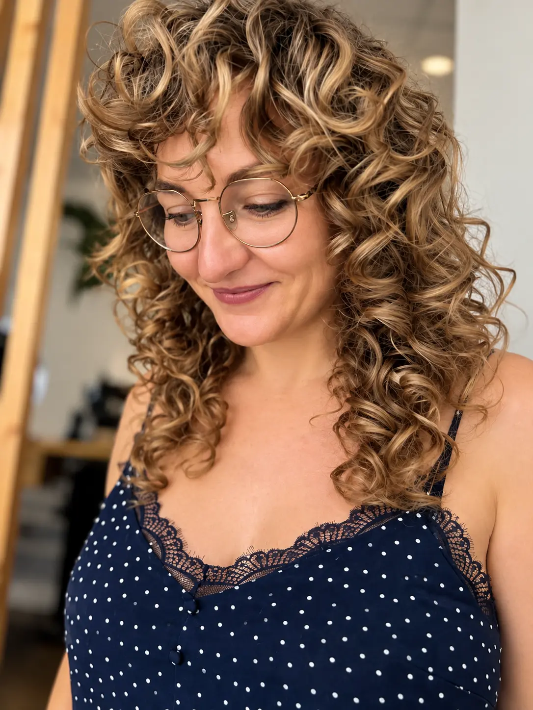 Boucles naturelles coiffées avec frange, cliente à lunettes